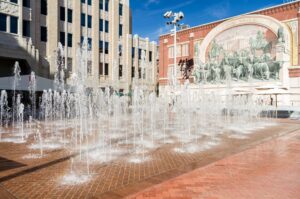 Sundance Square in Ft Worth TX with the fountains on during a sunny day, visiting sundance square is one of the fun things to do in fort worth texas