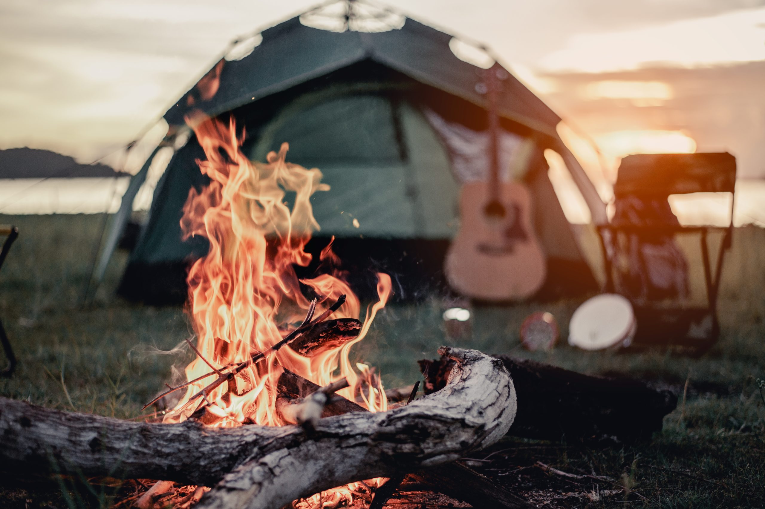 tent camping with a campfire in the foreground. there is plenty of great tent camping near austin tx