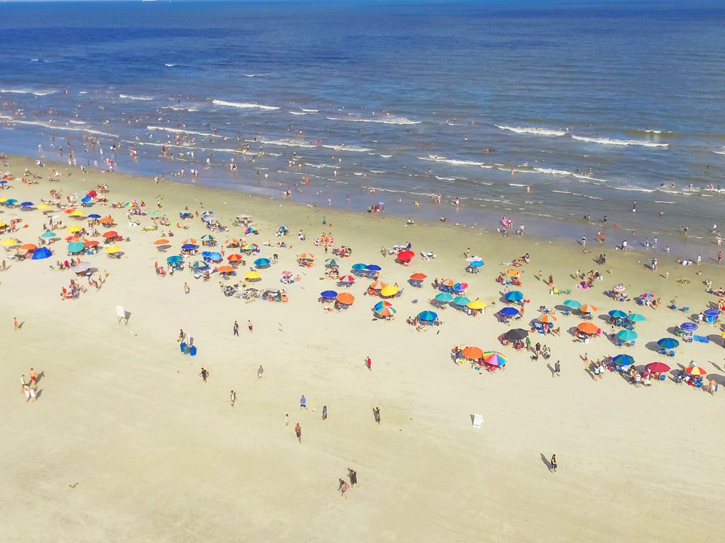 aerial view of colorful umbrellas and crowds in galveston, home to some of the best beaches in texas
