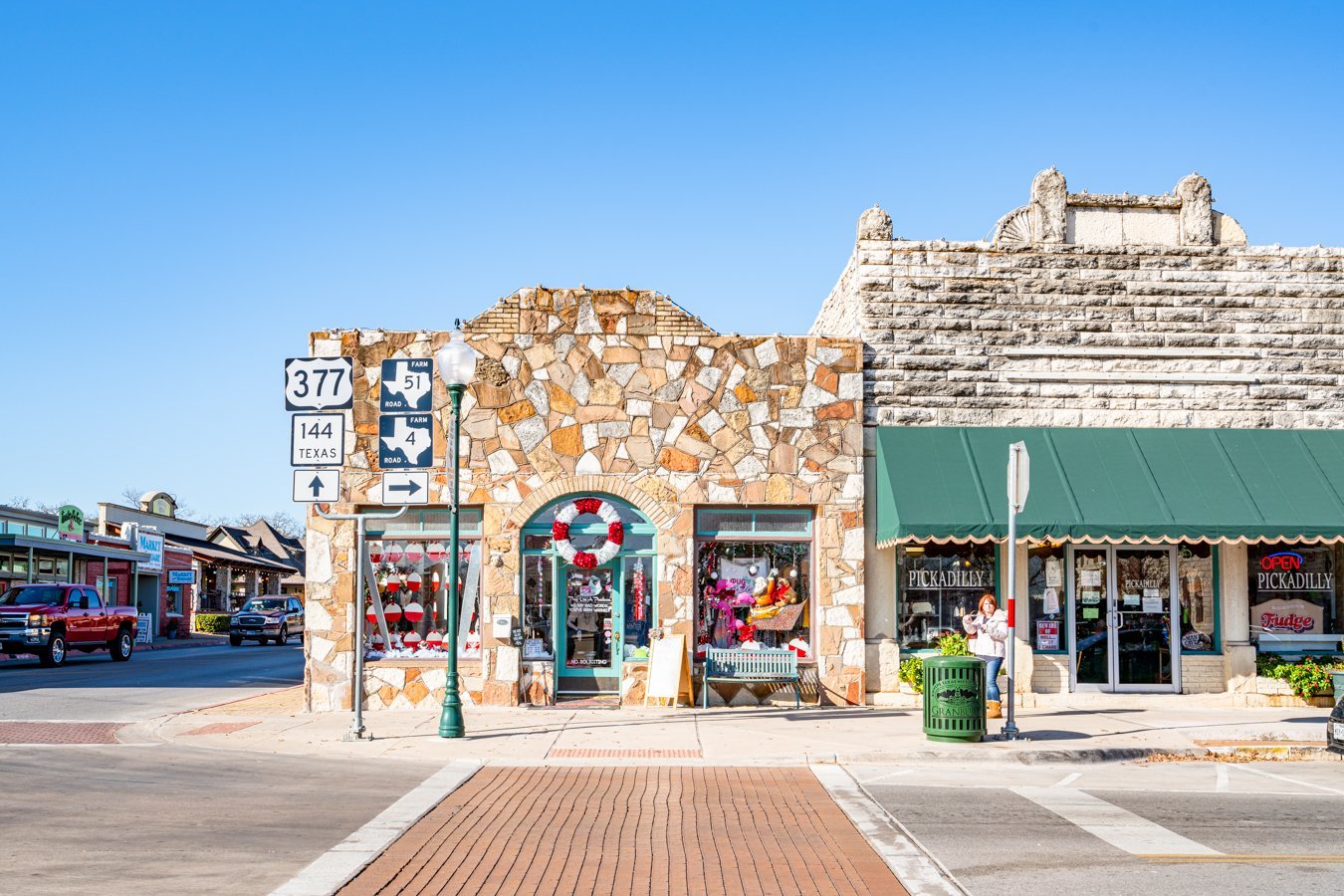 downtown granbury tx with two stone buildings as seen from across the street