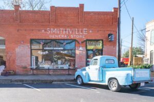 red brick general store with blue historic truck parked out front in smithville tx