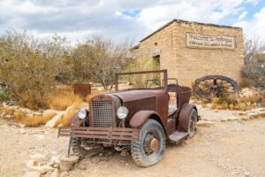 abandoned car parked in front of historic terlingua jail, one of the most famous ghost towns in texas