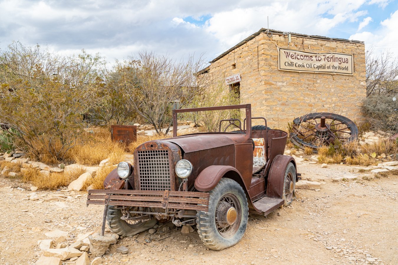 abandoned car parked in front of historic terlingua jail, one of the most famous ghost towns in texas