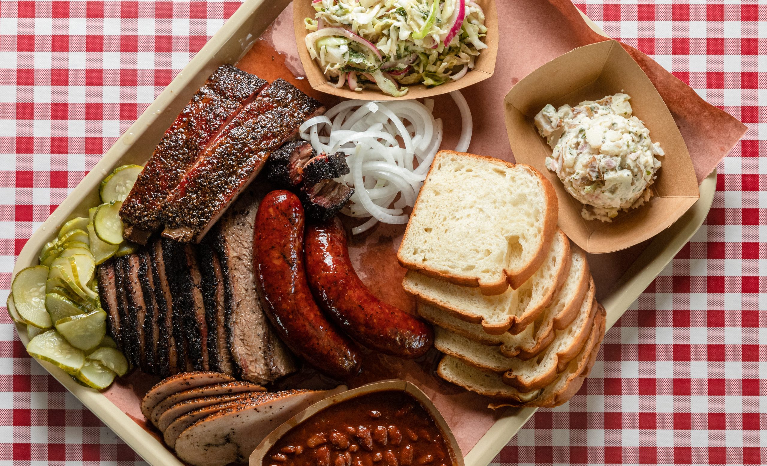 tray of texas bbq featuring brisket ribs sausage as seen from above