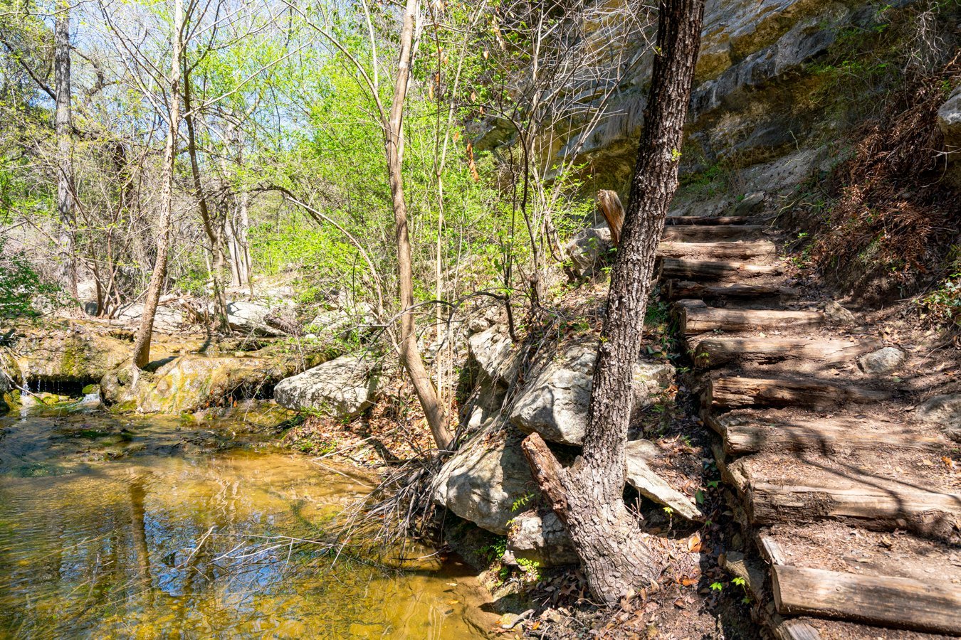 hiking steps of river place nature trail austin with small waterfall to the left