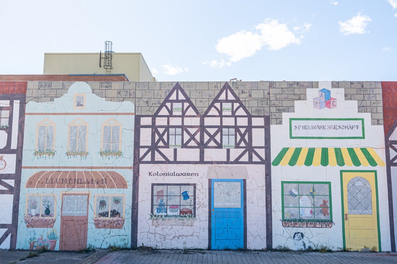 mural displaying painted german-style buildings, one of the best things to do in muenster texas is snap photos here