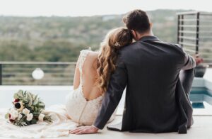 couple wearing wedding outfits overlooking the hill country at the beginning of a texas honeymoon destinations
